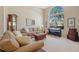 Cozy living room featuring plush seating, natural light from a large window, and a stylish piano at 11906 Middlebury Dr, Tampa, FL 33626