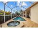 Spacious screened-in pool area with a hot tub and lush landscaping at 11906 Middlebury Dr, Tampa, FL 33626