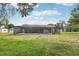 Large backyard with screened-in pool and expansive lawn, perfect for outdoor activities at 1226 Debuel Rd, Lutz, FL 33549