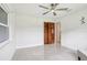Spacious bedroom featuring light gray floors, fan, closet, and a glimpse of the bathroom at 1226 Debuel Rd, Lutz, FL 33549