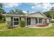 Inviting single-story house featuring a brick exterior, a cozy porch, and manicured landscaping at 1226 Debuel Rd, Lutz, FL 33549