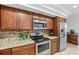 Updated kitchen with wood cabinets, stainless steel appliances, granite countertops and backsplash at 1226 Debuel Rd, Lutz, FL 33549