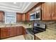 Kitchen featuring wood cabinets, stainless steel appliances, attractive countertops, and plenty of natural light at 1226 Debuel Rd, Lutz, FL 33549