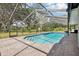 Screened-in pool area featuring pavers, ample space for lounging, and a relaxing atmosphere at 1226 Debuel Rd, Lutz, FL 33549