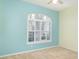Comfortable bedroom with a large window with shutters and neutral carpet at 1231 Corinth Greens Dr, Sun City Center, FL 33573