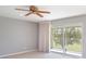 Bedroom with a ceiling fan, sliding glass doors leading to a balcony, and neutral carpet at 1231 Corinth Greens Dr, Sun City Center, FL 33573