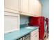 Laundry room with light cabinets, blue countertops, and red appliances at 1231 Corinth Greens Dr, Sun City Center, FL 33573