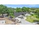 Aerial view of the single-story home with a large driveway, mature trees, and a serene pond at 12317 Smokey Dr, Hudson, FL 34669