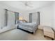 Sunlit bedroom with two windows, patterned bedding, neutral carpet, and a cushioned bench at 1241 N Mcmullen Booth Rd, Clearwater, FL 33759