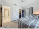 Inviting bedroom features patterned bedding, a window, and access to closet and hallway at 1241 N Mcmullen Booth Rd, Clearwater, FL 33759