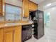 Efficient kitchen layout with black appliances, wood cabinets, and durable countertops at 1241 N Mcmullen Booth Rd, Clearwater, FL 33759