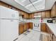 Traditional-style kitchen featuring wood cabinets, white appliances and tile flooring at 1241 N Mcmullen Booth Rd, Clearwater, FL 33759