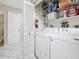 Functional laundry area with a washer, dryer, and shelving for storage, conveniently located near a hallway at 1241 N Mcmullen Booth Rd, Clearwater, FL 33759