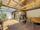 Bright, enclosed patio featuring a clear roof, plants, and comfortable seating areas at 1241 N Mcmullen Booth Rd, Clearwater, FL 33759