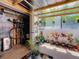 Sunroom patio with potted plants, hanging plants, and a bicycle, under a transparent roof at 1241 N Mcmullen Booth Rd, Clearwater, FL 33759