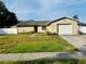 Charming single-story home featuring an attached garage and a traditional lawn at 13924 Pathfinder Dr, Tampa, FL 33625
