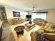 Comfortable living room with neutral tones, tile flooring, a ceiling fan, and sliding glass doors to the backyard at 13924 Pathfinder Dr, Tampa, FL 33625