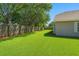 Spacious backyard with green lawn, wooden fence, and mature trees at 1517 Little Brook Ln, Brandon, FL 33511