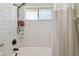 Clean bathroom featuring a white subway tile shower with dark fixtures and a shower curtain at 1517 Little Brook Ln, Brandon, FL 33511