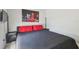 Comfortable bedroom with a large bed, red pillows, and a mounted TV at 1517 Little Brook Ln, Brandon, FL 33511