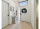 Bright and inviting foyer featuring neutral tiling and an attractive front door with wreath at 1517 Little Brook Ln, Brandon, FL 33511