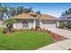 Charming home featuring a well-manicured lawn and beautiful landscaping, with a neutral exterior and attached garage at 1517 Little Brook Ln, Brandon, FL 33511
