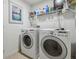Functional laundry room featuring a washer, dryer, and storage shelves at 1517 Little Brook Ln, Brandon, FL 33511