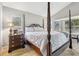 Bright main bedroom featuring a four-poster bed, hardwood floors, and a bedside table at 1517 Little Brook Ln, Brandon, FL 33511