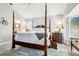Bright main bedroom featuring a four-poster bed, hardwood floors, and ensuite bathroom at 1517 Little Brook Ln, Brandon, FL 33511