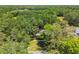 An aerial view of a home nestled among the trees with a front yard, driveway and quiet street at 1816 Curry Rd, Lutz, FL 33549