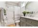 Bathroom with gray vanity, round mirror, and shower/tub combo at 1816 Curry Rd, Lutz, FL 33549