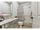 Bathroom featuring tiled floors, decorative mirror, a vanity, and a shower and bath combo with a patterned shower curtain at 1816 Curry Rd, Lutz, FL 33549