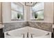 Close-up of the corner bathtub with chrome fixtures and decorative ledge with plants at 1816 Curry Rd, Lutz, FL 33549