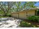 Spacious three-car garage with tan doors and exterior lights surrounded by green landscaping at 1816 Curry Rd, Lutz, FL 33549
