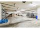 Spacious, unfinished garage space with shelving, extra refrigerators, and ample room for storage and parking at 1816 Curry Rd, Lutz, FL 33549