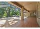 A covered patio with tiled floors and view of the pool and nature from the screened-in enclosure at 1816 Curry Rd, Lutz, FL 33549