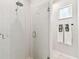 Shower features a glass door, rain shower head, and stylish white tiling at 1816 Curry Rd, Lutz, FL 33549