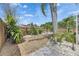 Side yard landscaped with palm trees, stone, and a wooden fence at 221 Lakeway Ln, Apollo Beach, FL 33572
