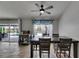 Dining area with a dark wood table set, travertine floors, and views of the pool area through sheer curtains at 221 Lakeway Ln, Apollo Beach, FL 33572