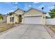 Home featuring a well-manicured lawn, palm trees, a driveway, and a two-car garage at 221 Lakeway Ln, Apollo Beach, FL 33572