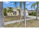 Home featuring a well-manicured lawn, palm trees, a driveway, and a two-car garage at 221 Lakeway Ln, Apollo Beach, FL 33572