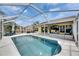 A beautiful screened-in pool with ample patio space, seating, and a TV, perfect for outdoor entertaining at 221 Lakeway Ln, Apollo Beach, FL 33572