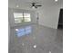 Open living room features sleek gray floors, a ceiling fan, and bright natural light at 2528 Columbus S Way, St Petersburg, FL 33712