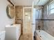 Updated bathroom with a white vanity, round mirror, and tiled shower and bath at 2600 N Paula Dr # 2B, Dunedin, FL 34698