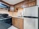 Compact kitchen features stainless steel appliances, granite countertops, and wood cabinetry at 2600 N Paula Dr # 2B, Dunedin, FL 34698
