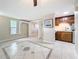 Open-concept living space with tile floors, small kitchen, and view into the next room at 2600 N Paula Dr # 2B, Dunedin, FL 34698