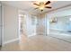View of the bright living room featuring tile flooring and a ceiling fan at 2600 N Paula Dr # 2B, Dunedin, FL 34698