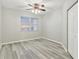 Bedroom with wood floors, a ceiling fan, large window, and a closet with white paneled doors at 2625 Terra Ceia Bay Blvd # 406, Palmetto, FL 34221