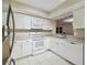 Bright kitchen featuring white cabinets, granite countertops, stainless steel refrigerator, and modern appliances at 2625 Terra Ceia Bay Blvd # 406, Palmetto, FL 34221