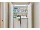 Neat laundry closet features washer and dryer units as well as overhead shelving for storage at 2625 Terra Ceia Bay Blvd # 406, Palmetto, FL 34221